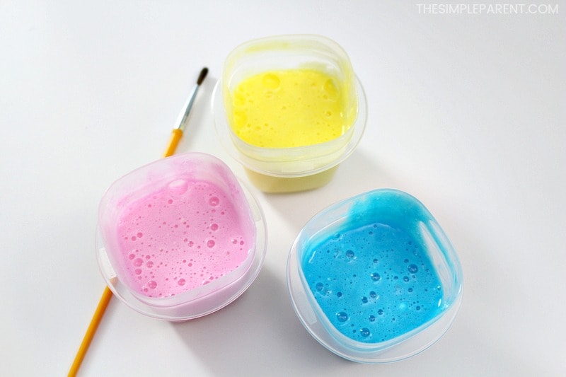 Containers of kids bath paint in pink, yellow, and blue.
