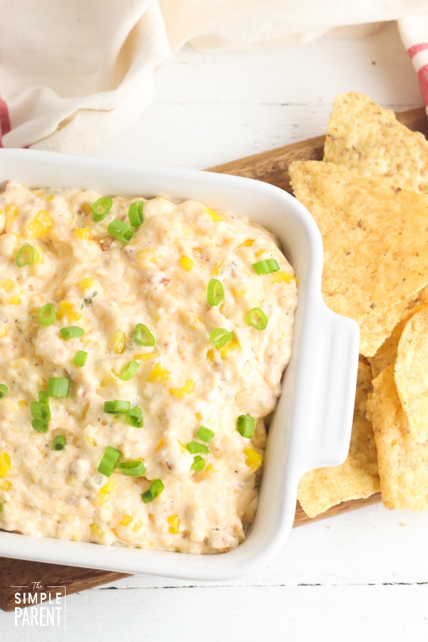 Crack Corn Dip in a white dish with tortilla chips on the side