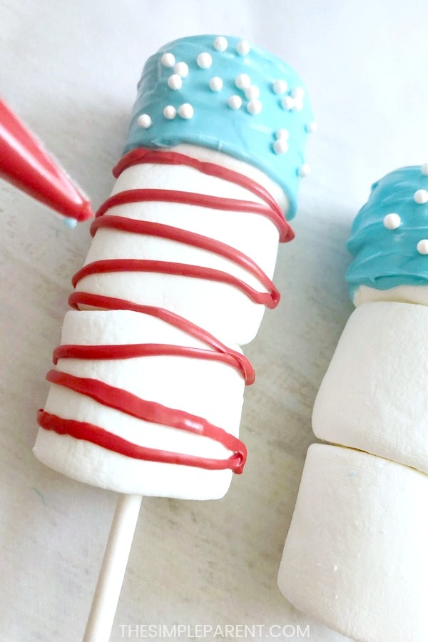 Adding red stripes to 4th of July marshmallow pops