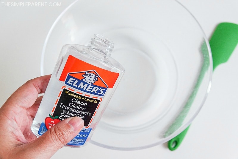 Putting clear glue in a bowl to make blue slime