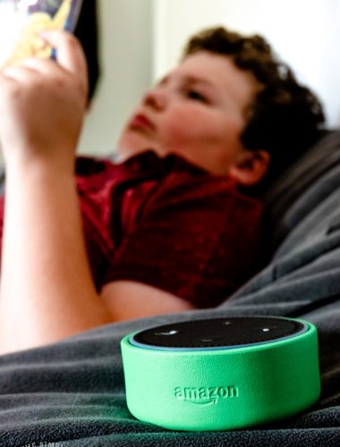 Boy reading a book with Alexa on Amazon Echo Dot Kids Edition