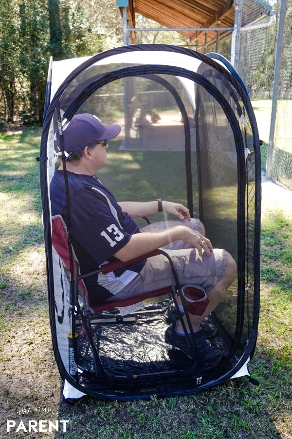Baseball dad sitting in an Under the Weather pod at the baseball field