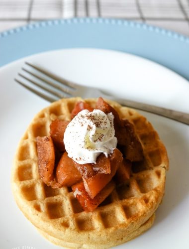 Crockpot cinnamon apples on waffle with whipped cream