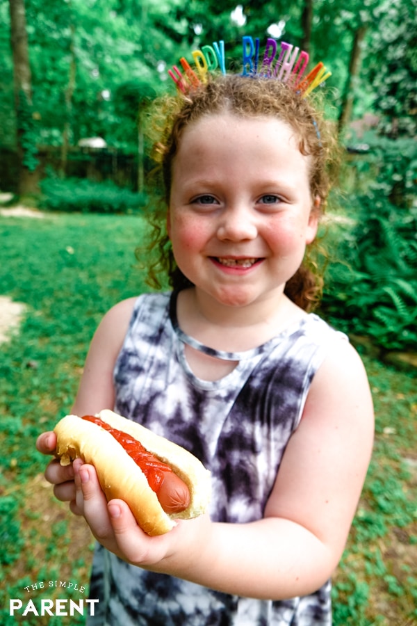 Girl eating a hot dog in the backyard