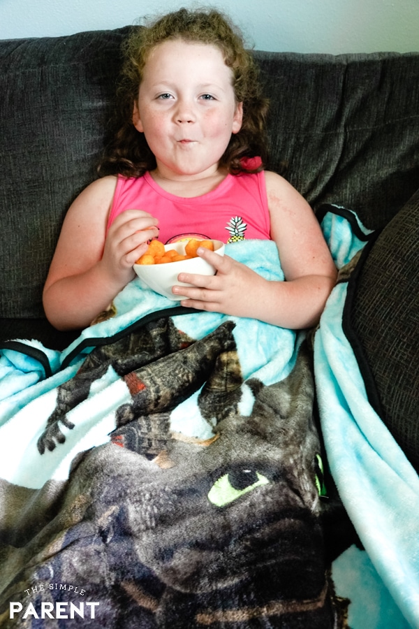 Girl eating cheese balls while watching How to Train Your Dragon 3 Movie