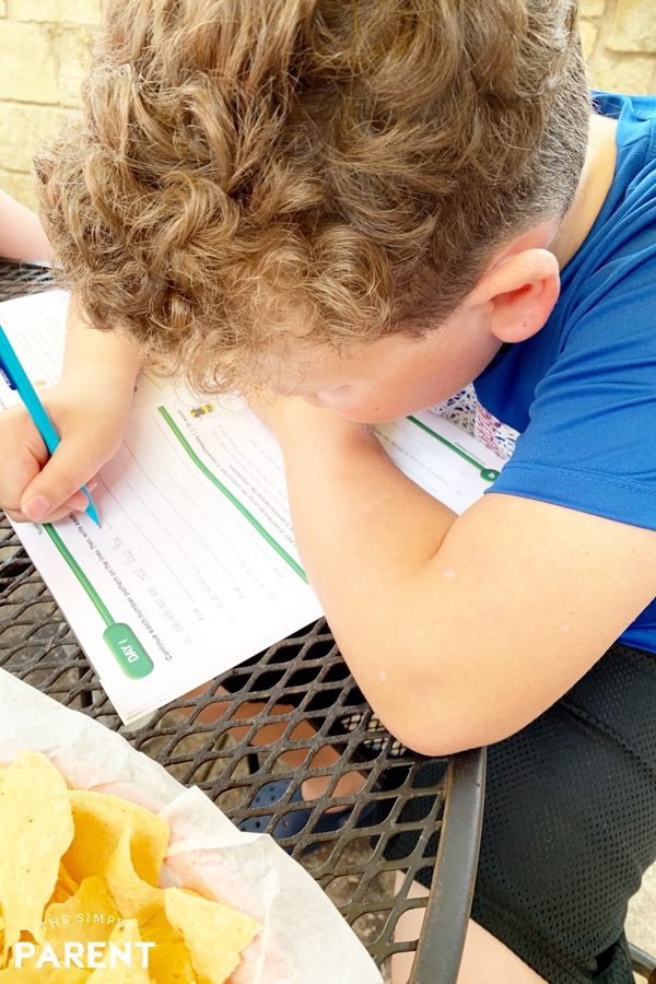 Boy working in summer Learning workbook