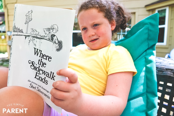 Young girl reading Where the Sidewalk Ends by Shel Silverstein