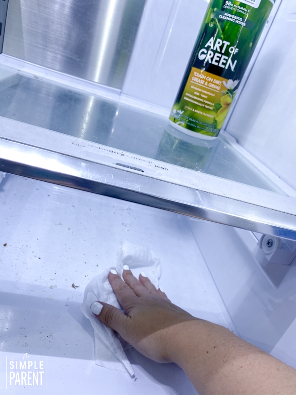 Cleaning refrigerator shelf with Art of Green cleaning wipes