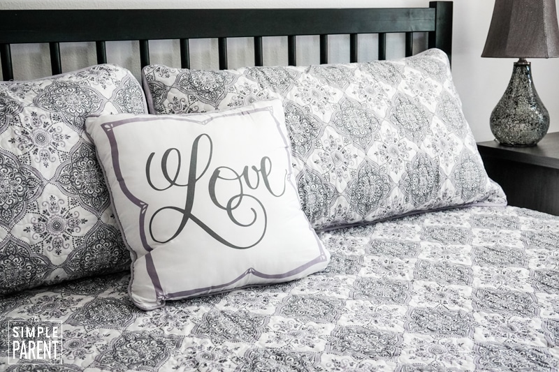 Gray and white quilt bedding set with pillow that says LOVE on it