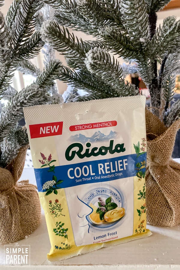 Bag of Ricola Cool Relief Lemon Frost Drops sitting in front of Christmas trees