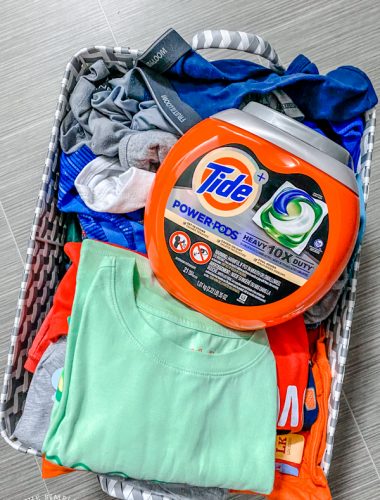 Basket of laundry with Tide Power Pods container sitting on top