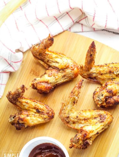 Air Fryer Chicken Wings on a cutting board with BBQ sauce