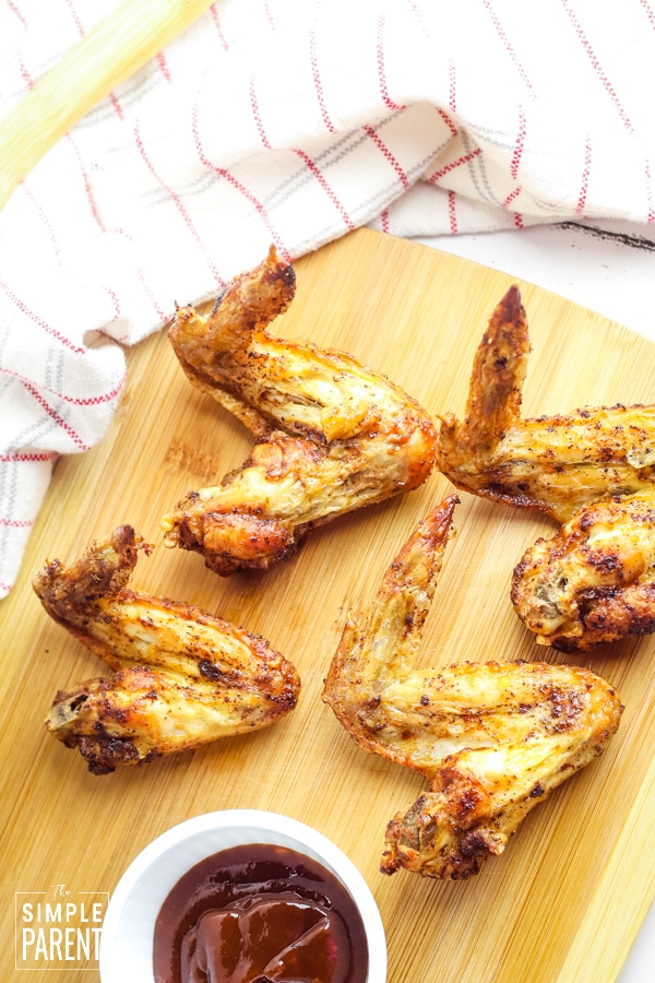 Air Fryer Chicken Wings on a cutting board with BBQ sauce