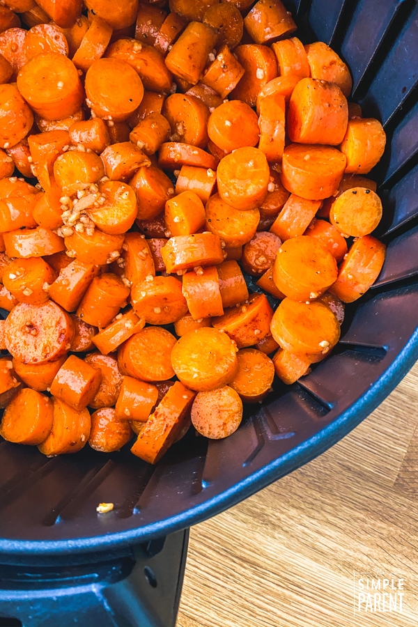 Chopped carrots with garlic in an air fryer basket