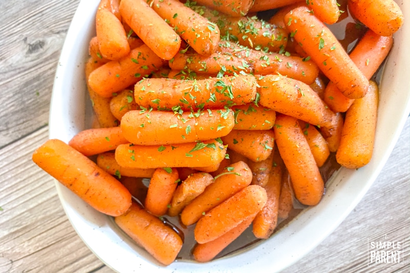 Brown sugar honey glazed carrots in a white serving dish