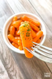 Bowl of Instant Pot Carrots and a fork with one carrot on it