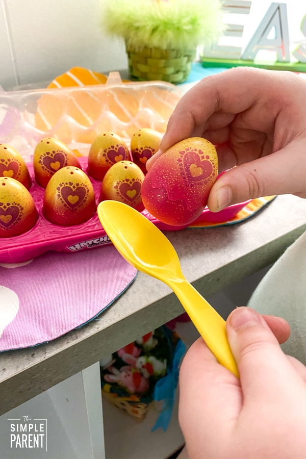 Child putting an egg on a spoon for an egg relay race Easter game