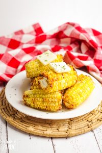 Plate of Air Fryer Corn on the Cob with a pats of butter on top