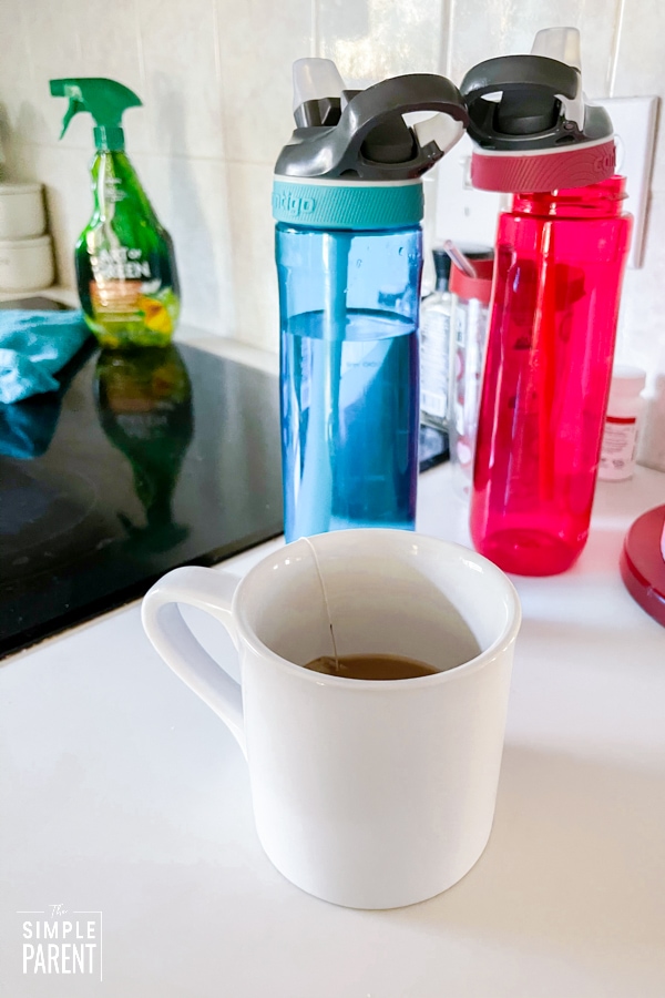 Water bottles and cup of tea on kitchen counter