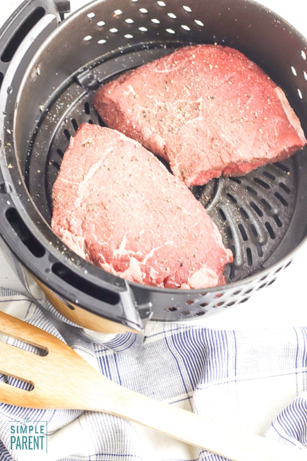 Raw sirloin steak in air fryer basket