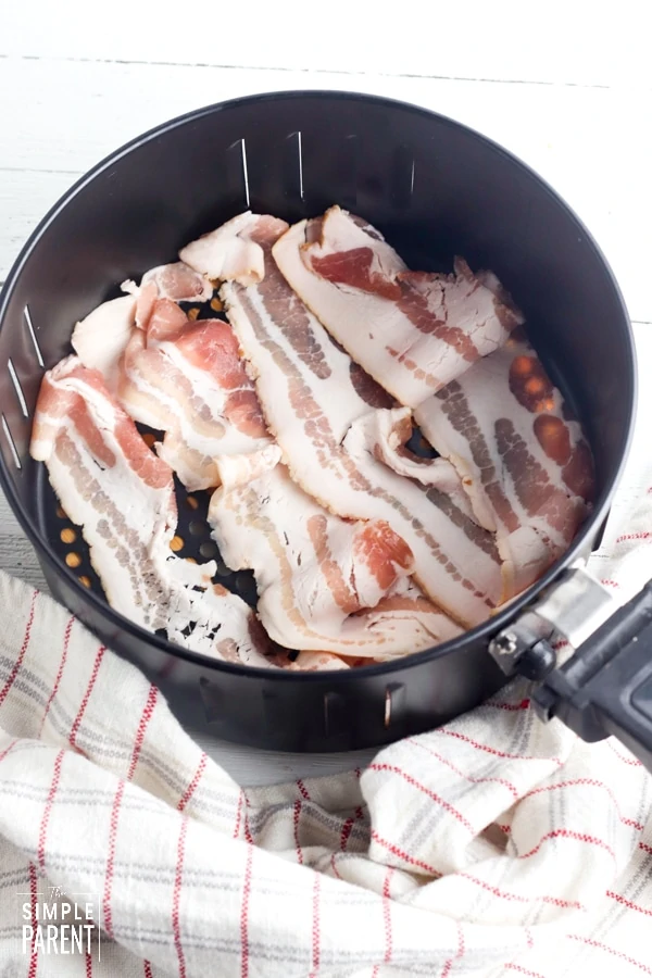 Raw bacon slices in air fryer basket