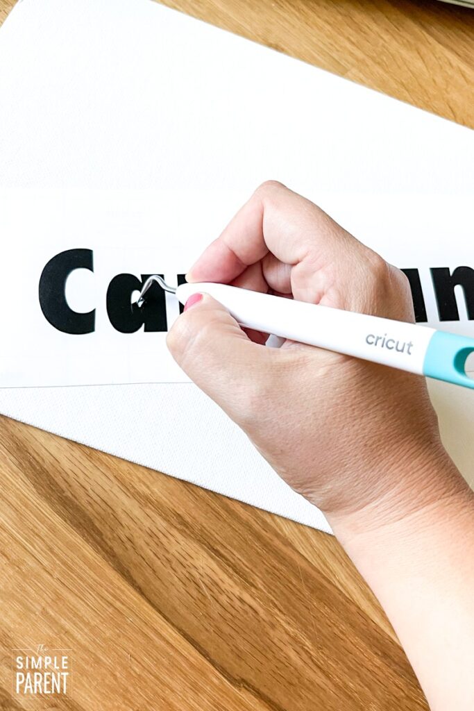 Using Cricut weeding tool to remove vinyl from letters