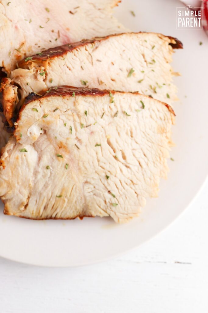 Sliced turkey breast on white serving plate