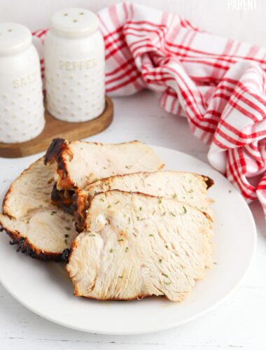 Slices of air fried turkey on white plate with red checkered napkin