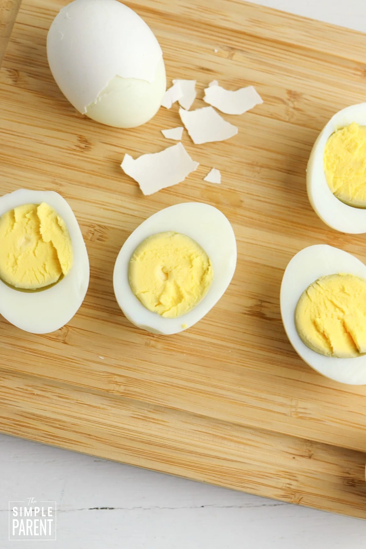Sliced hard boiled eggs laying on wooden cutting board
