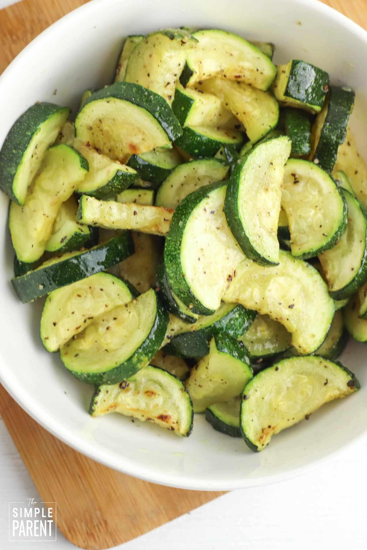 Roasted zucchini slices in white serving bowl