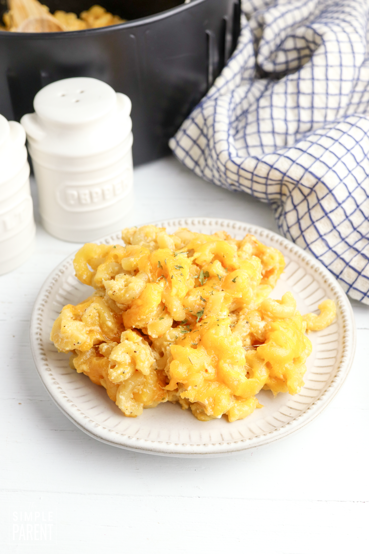 Air Fryer mac and cheese on white plate with blue and white checkered napkin.
