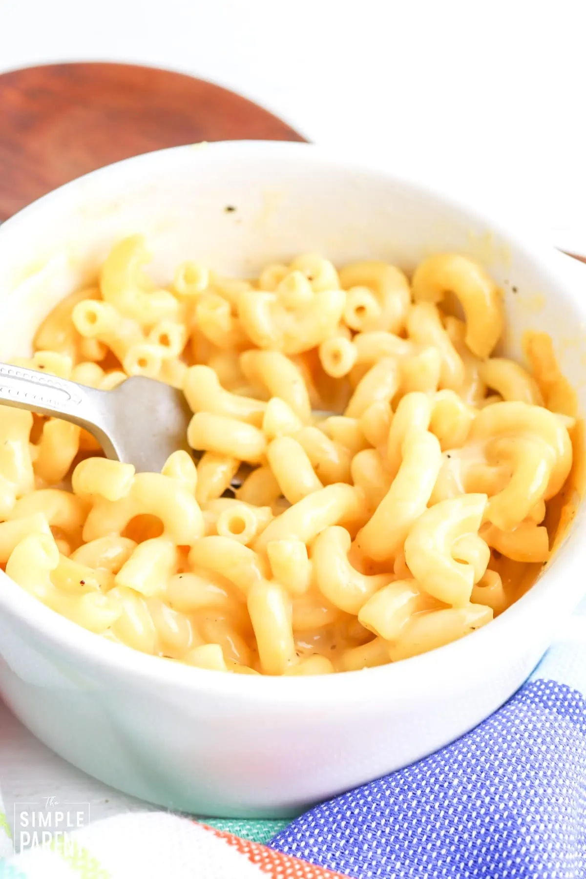 Microwave macaroni and cheese in a white bowl with a fork in it