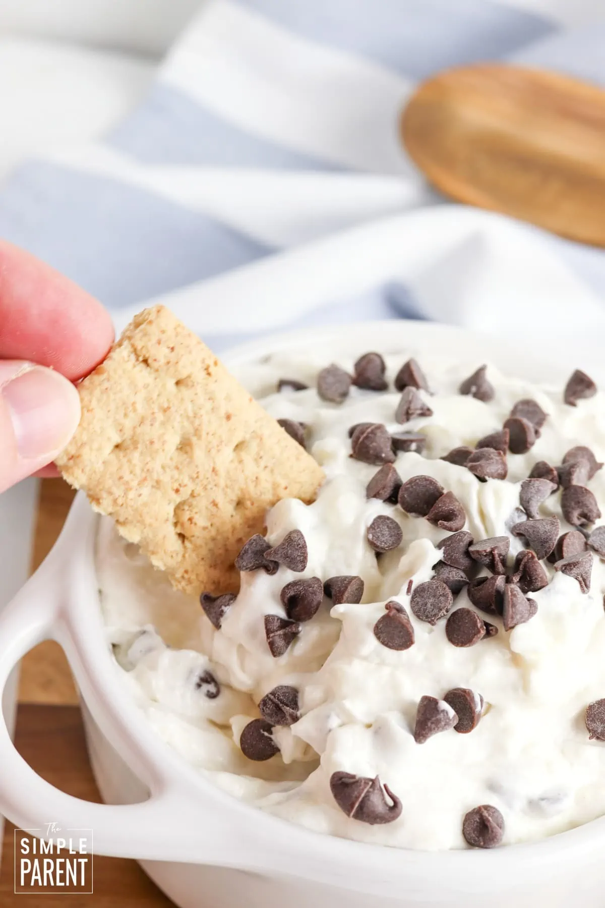 Graham cracker dipping in Booty Dip topped with mini chocolate chips