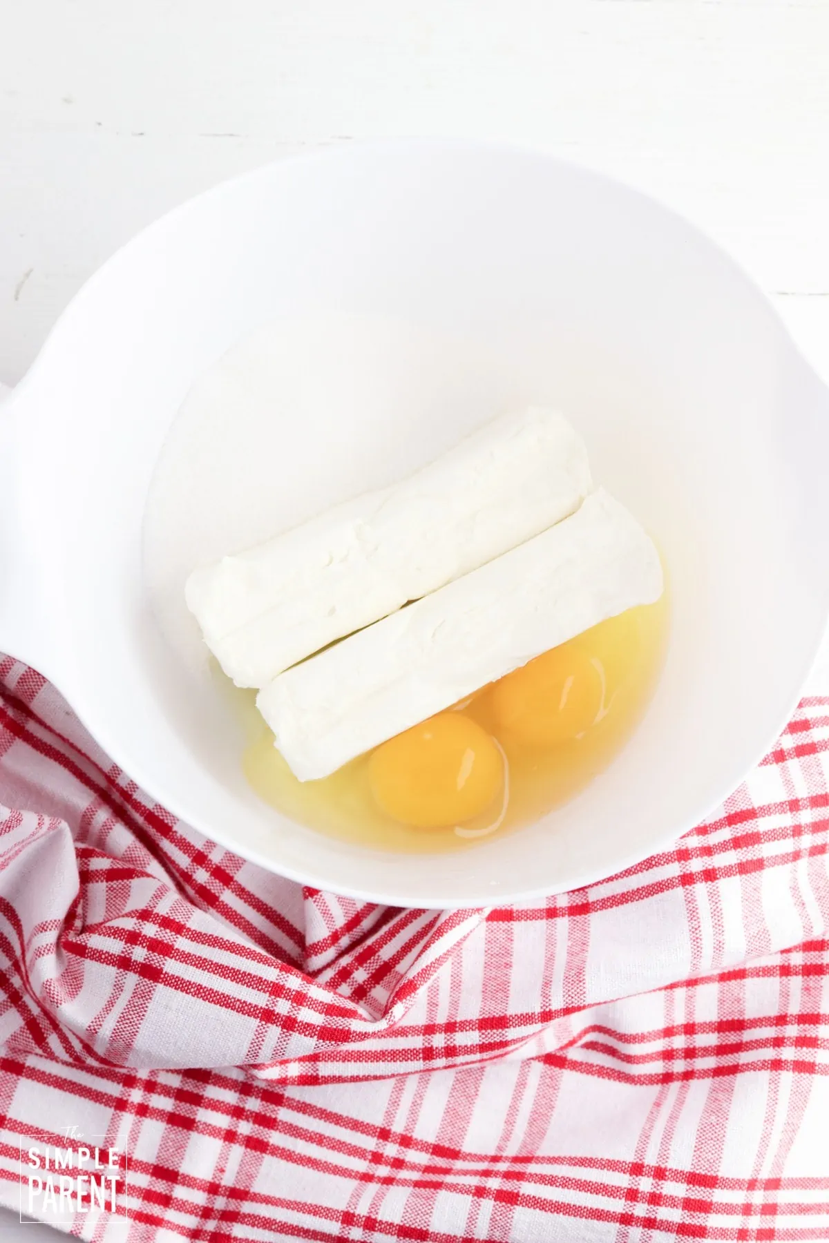 Butter and eggs in white mixing bowl