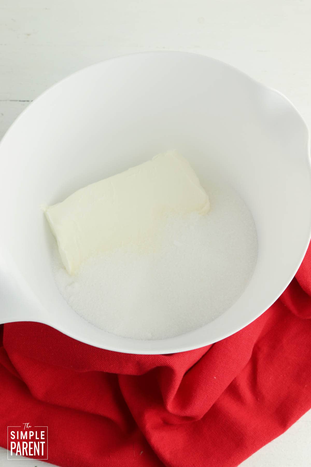 Cream cheese and sugar in white mixing bowl