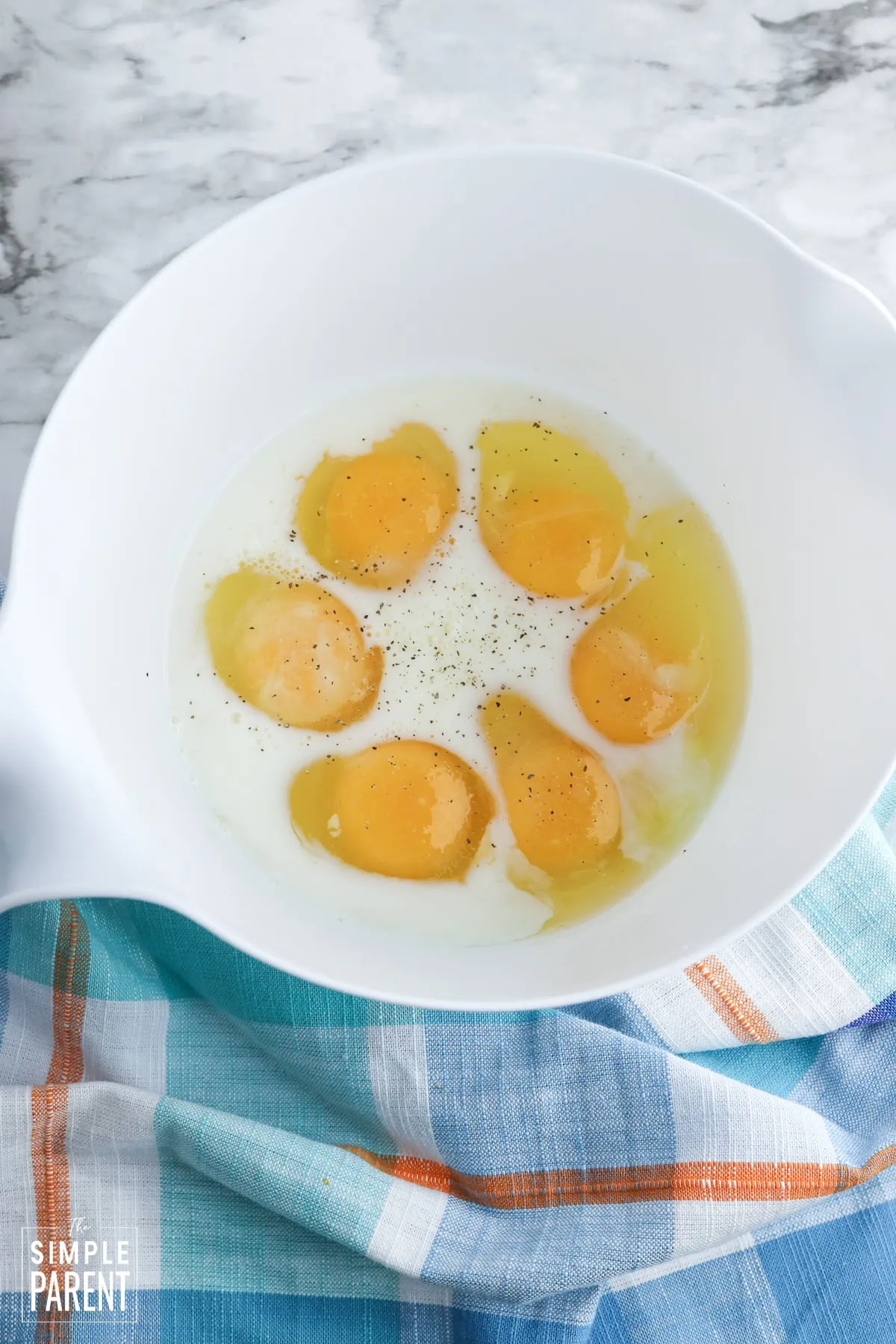 Milk and eggs in white mixing bowl