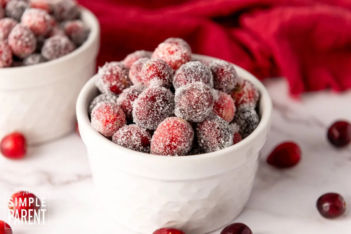White bowl of candied cranberries on a white counter