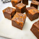 Pieces of Chocolate Caramel Fudge on white cutting board