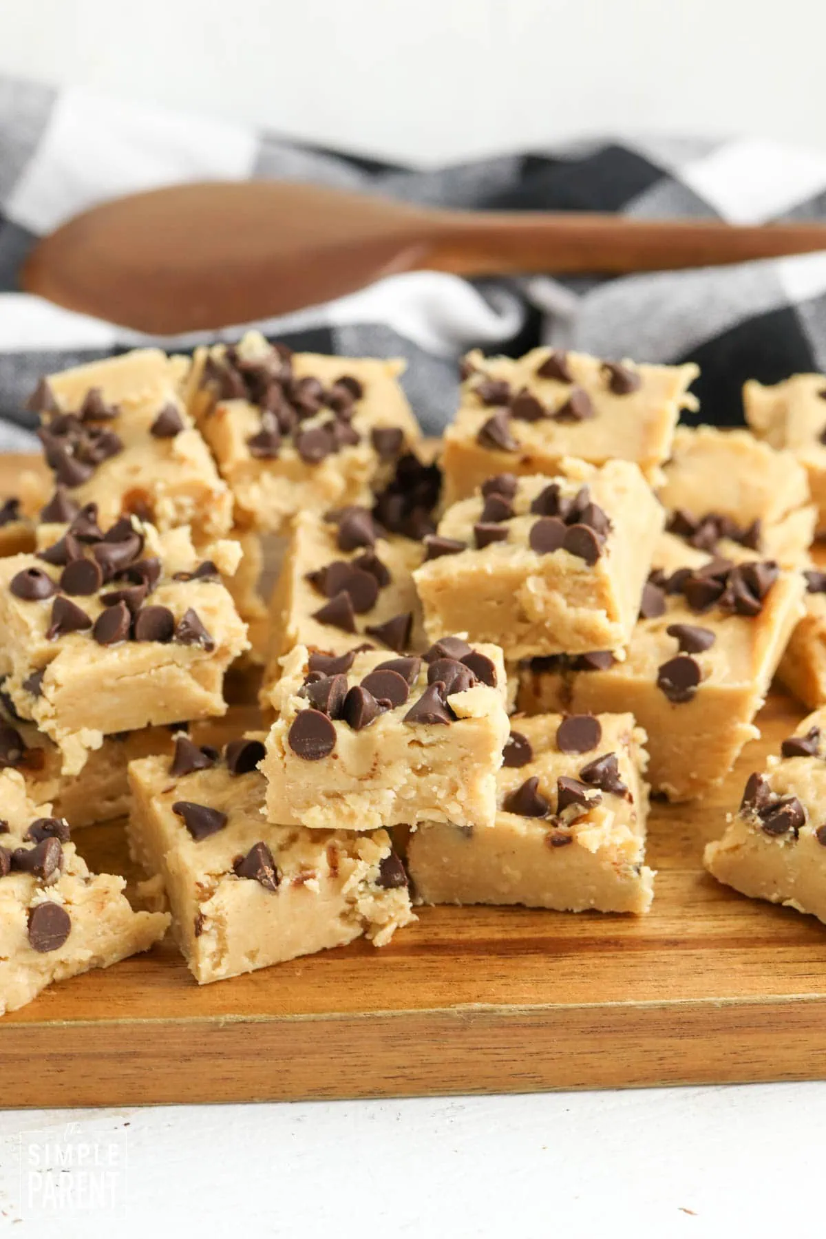 Christmas peanut butter fudge pieces stacked on wooden cutting board