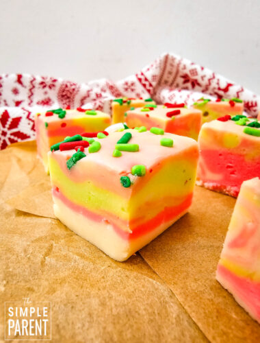 Squares of holiday white chocolate fudge on brown parchment paper