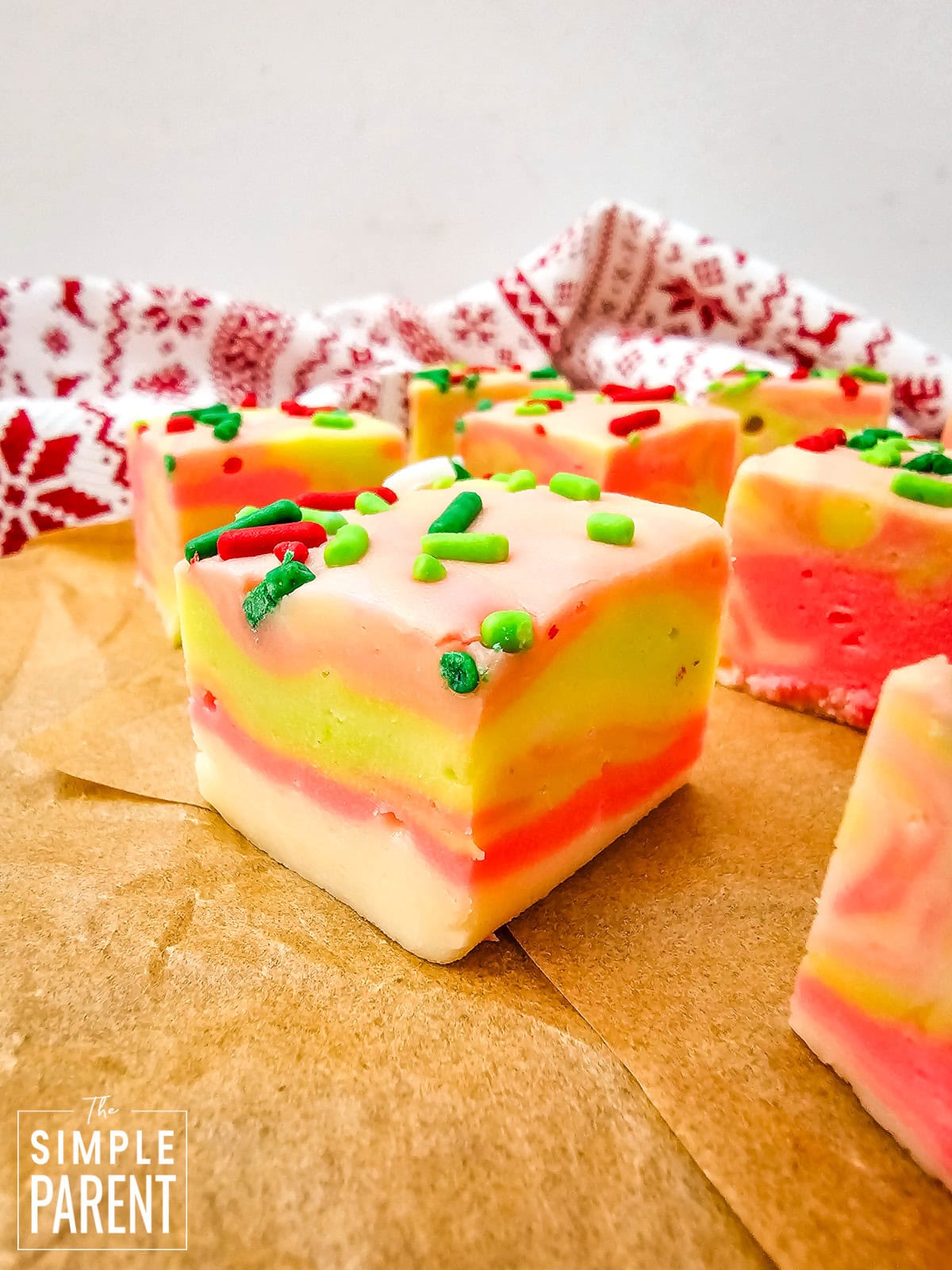 Squares of holiday white chocolate fudge on brown parchment paper