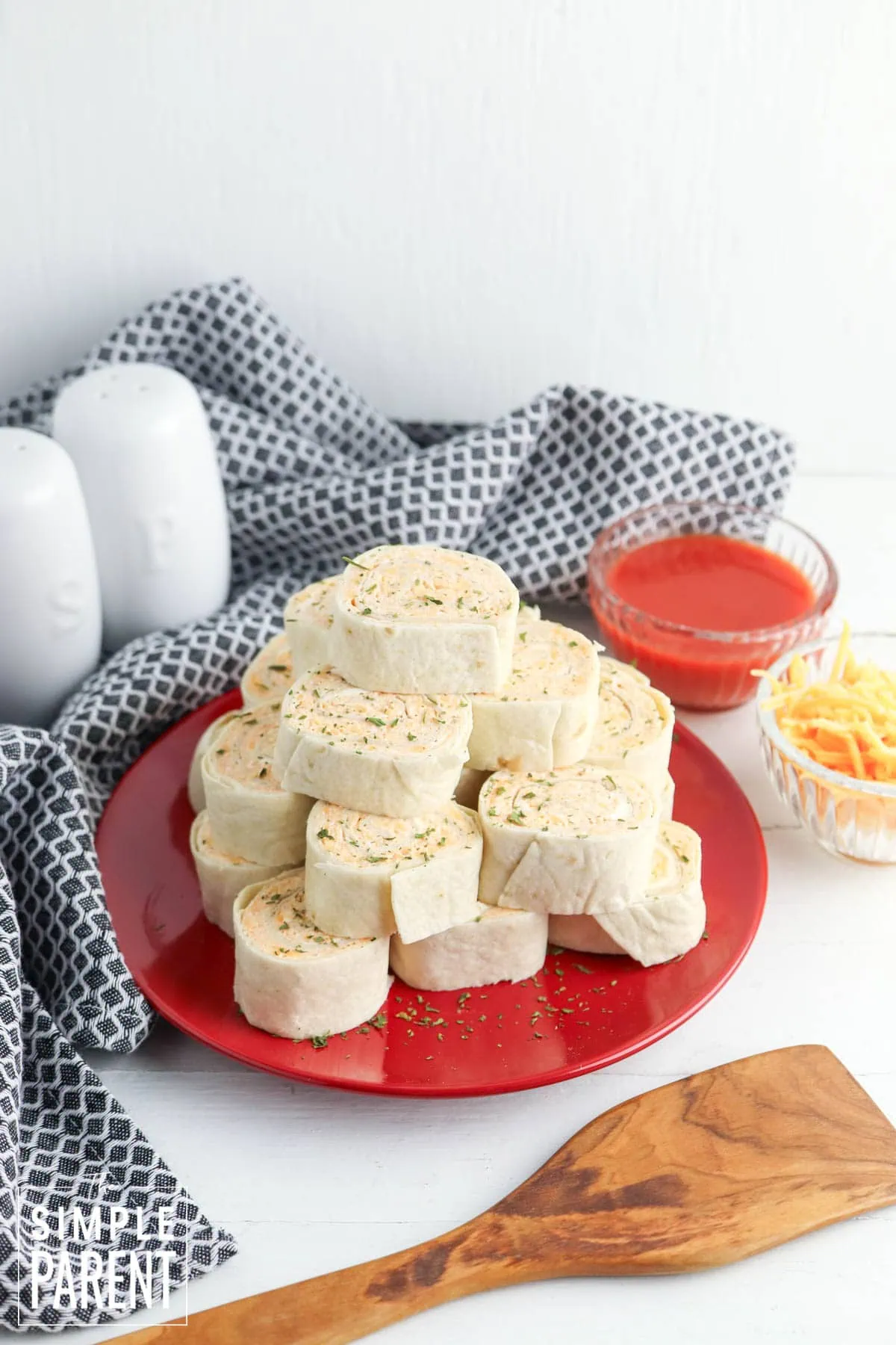 Buffalo Chicken Wrap Pinwheels stacked on red plate