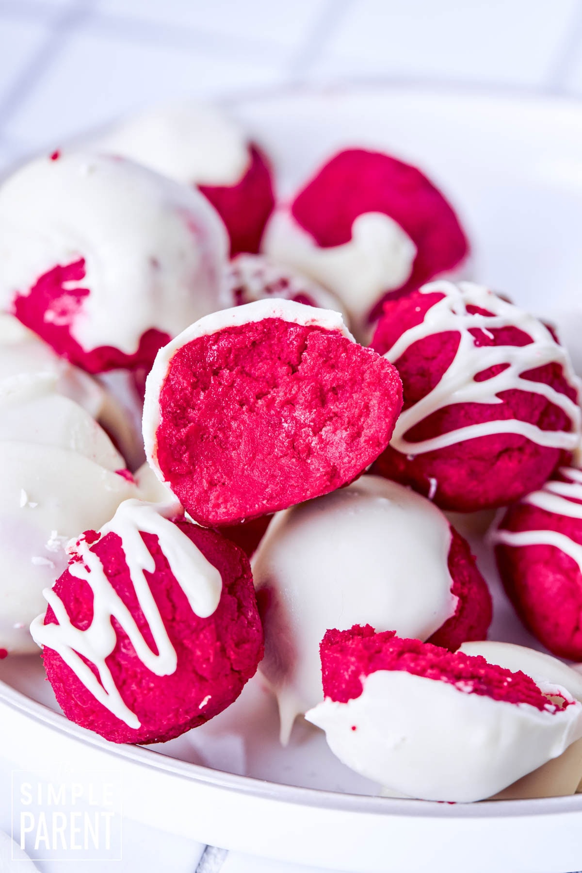Red velvet cake balls with white icing in white bowl