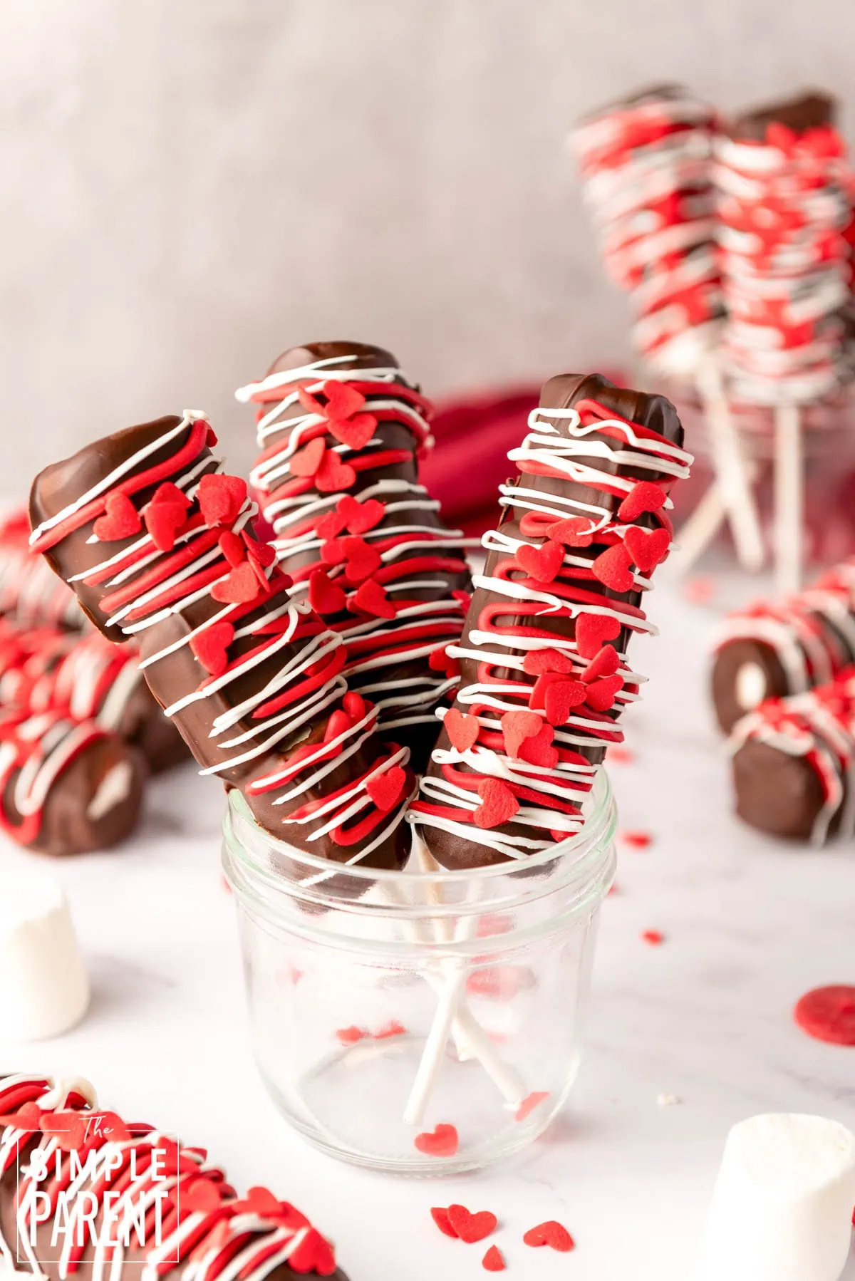 Valentine Marshmallow pops cover in chocolate with red sprinkles in a glass jar