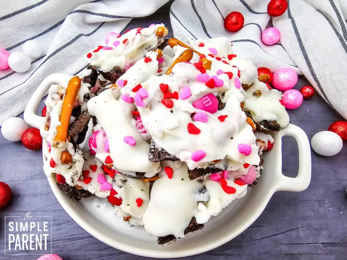 Pieces of Valentines Bark with pretzels and Oreos in white bowl