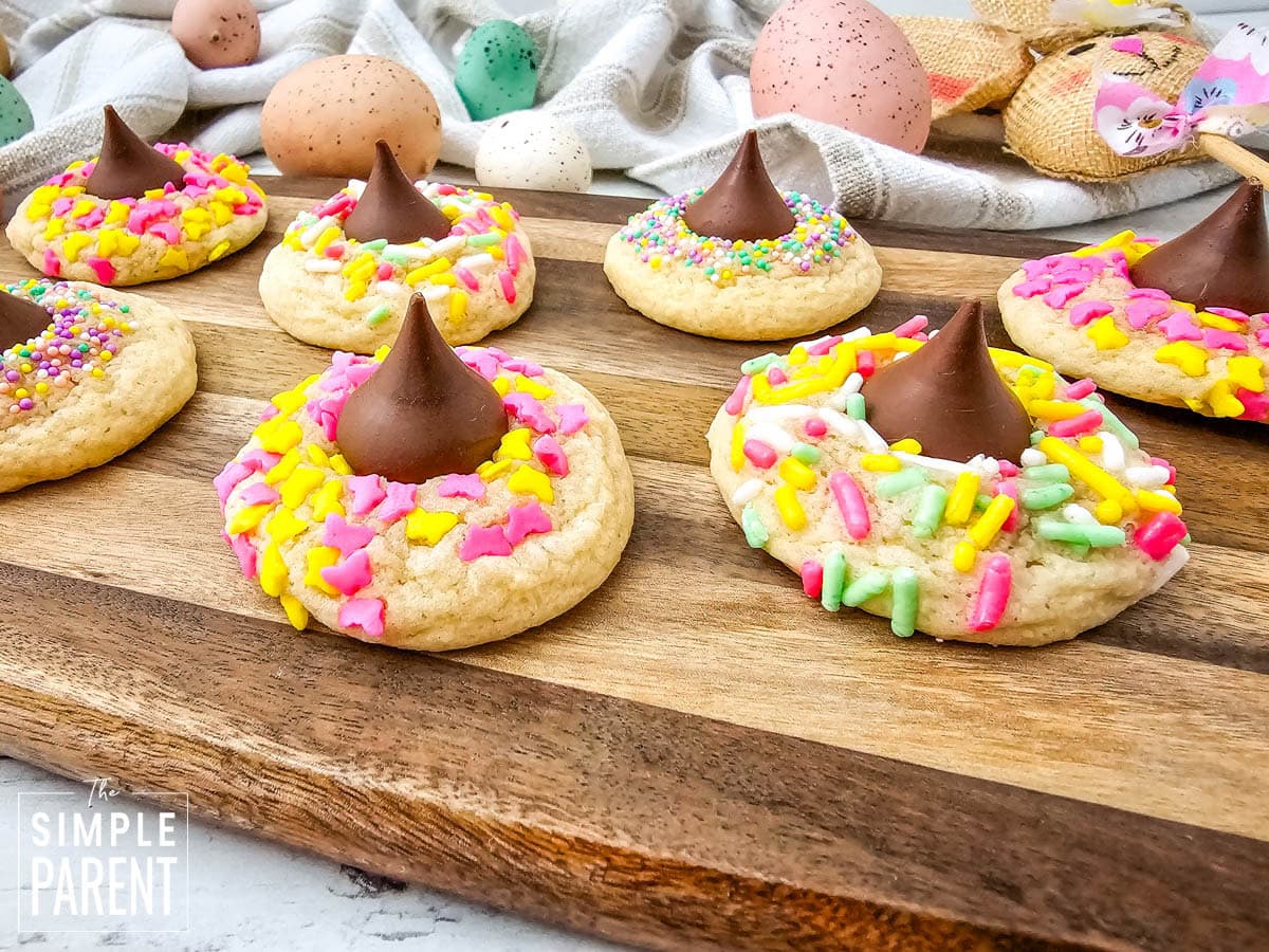 Easter sugar cookies with kiss and sprinkles on wooden cutting board