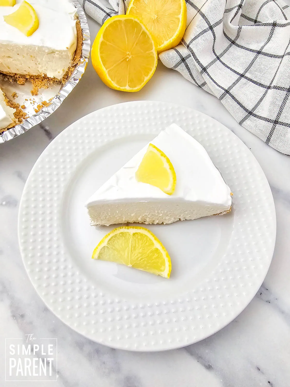 Slice of No Bake Lemon Custard Pie on white plate with lemon slice