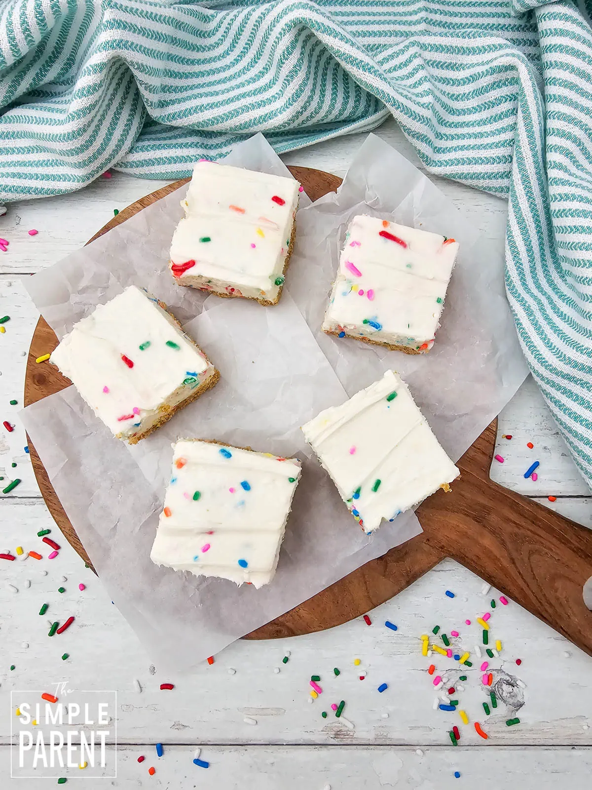 no bake spring cheesecake bars on parchment paper and wooden cutting board