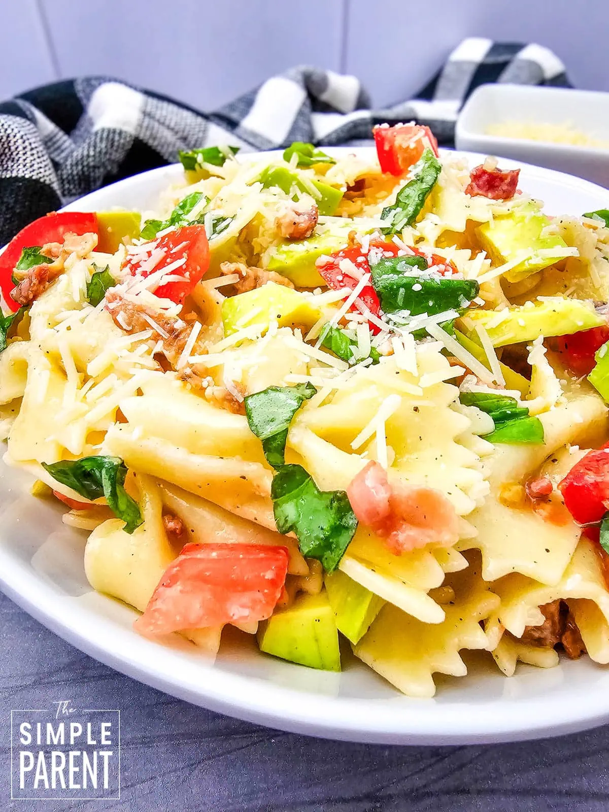 bow tie pasta salad with avocado on white serving plate