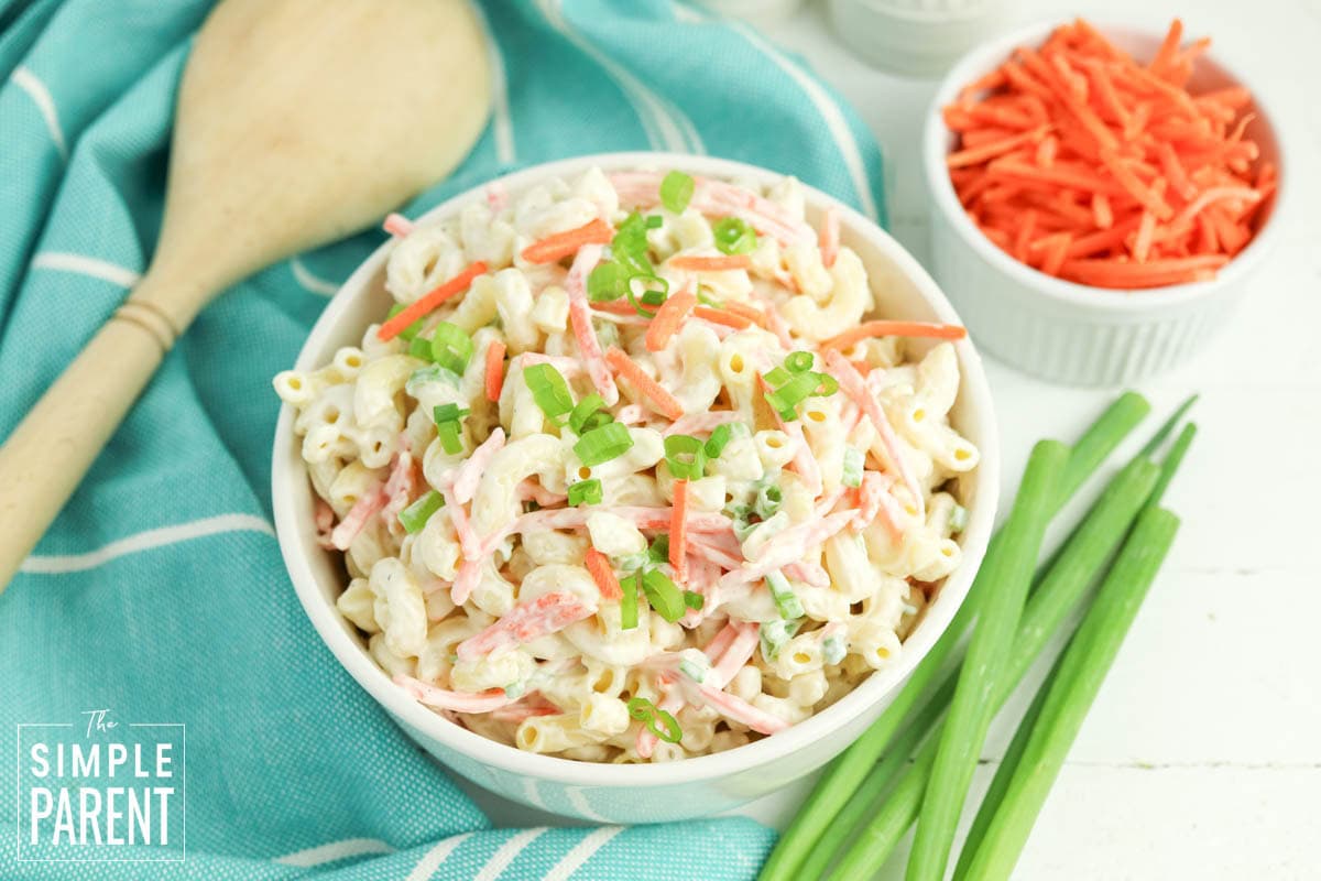 cold macaroni salad recipe in white bowl and wooden serving spoon